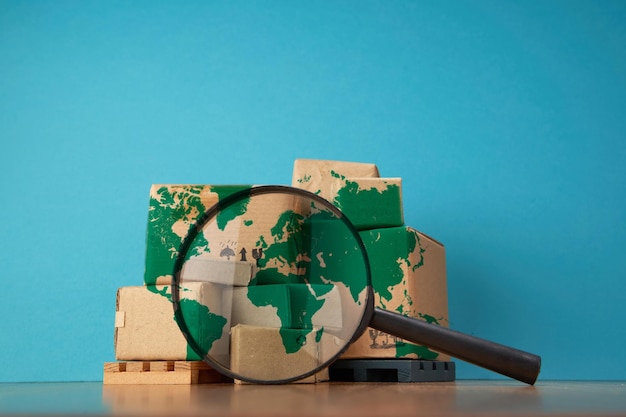 Magnifying glass and small cardboard box on blue background