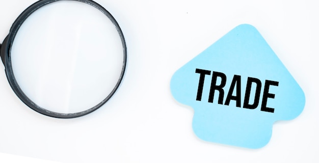 Magnifying glass with blue arrow paper sheet with text trade