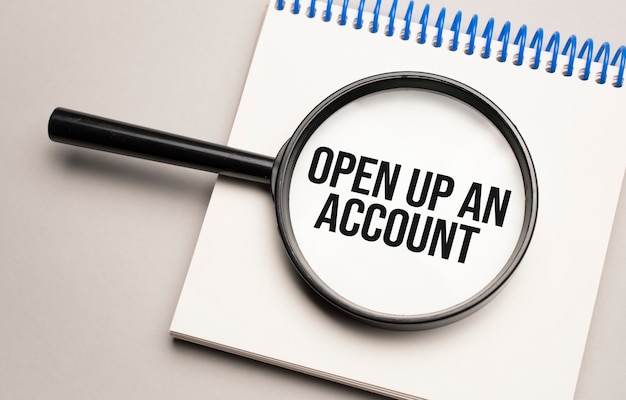 Magnifying glass with the word OPEN UP AN ACCOUNT on chart background