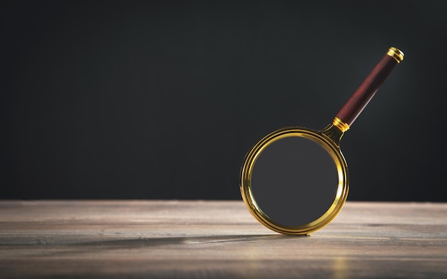 Magnifying glass on the wooden table.