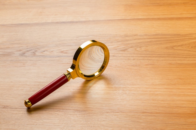 Magnifying glass on the wooden table