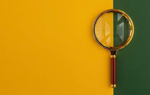 Premium Photo | Magnifying glass over yellow and green background