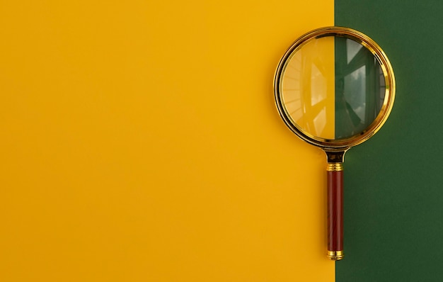 Magnifying glass over yellow and green background