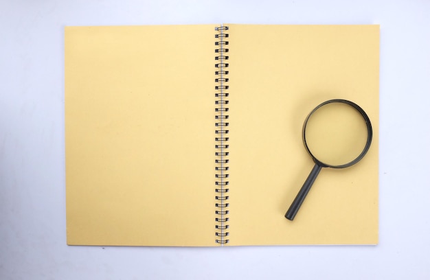 a magnifying glass on a yellow notebook