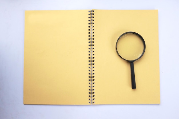 a magnifying glass on a yellow notebook