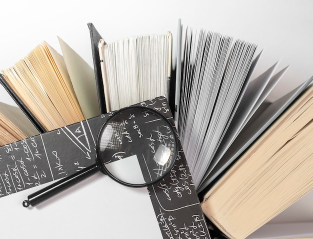 Foto lente d'ingrandimento su libri con molte pagine concetto di educazione e studio della conoscenza