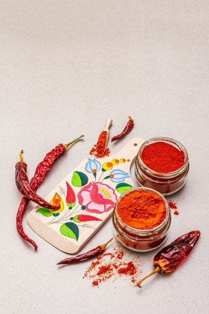 Magyar (ungherese) polvere di paprika rossa dolce e calda. modello tradizionale su un tagliere, diverse varietà di pepe secco.