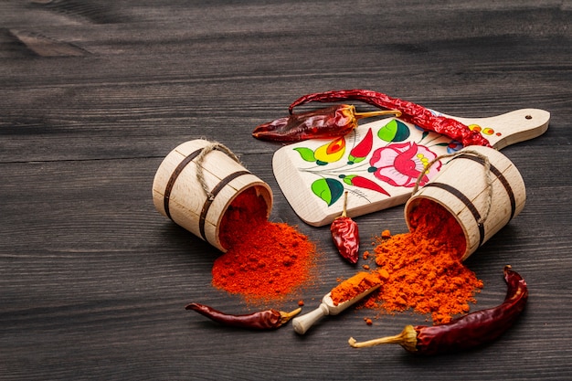 Magyar (Hungarian) red sweet and hot paprika powder. Traditional pattern on a cutting board, different varieties of dry pepper.