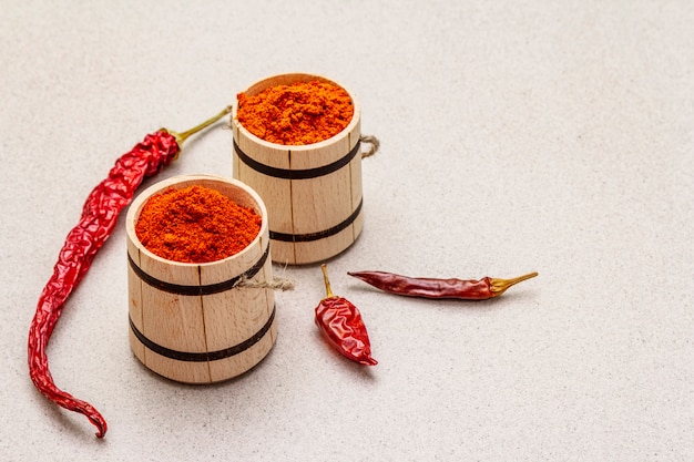 Photo magyar (hungarian) red sweet and hot paprika powder. traditional seasoning for cooking national food, different varieties of dry pepper. wooden kegs,