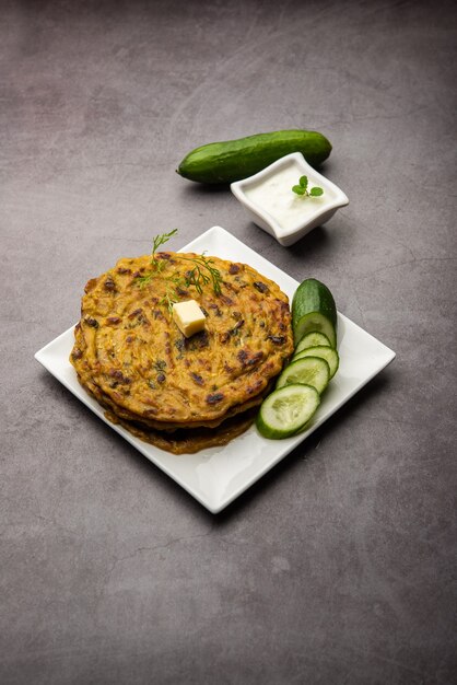 Maharashtrn Kakdi Thalipeeth of Punjabi komkommer paratha, gemaakt van vers geraspte kheera voor het ontbijt en serveer het samen met yoghurt