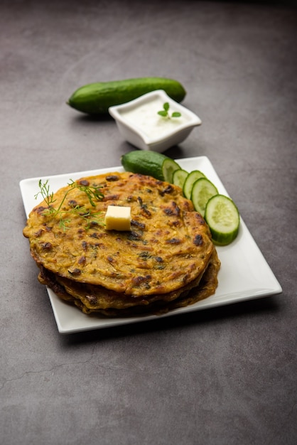 Maharashtrn Kakdi Thalipeeth of Punjabi komkommer paratha, gemaakt van vers geraspte kheera voor het ontbijt en serveer het samen met yoghurt