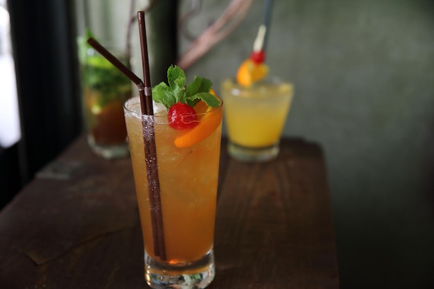 Mai tai cocktail met oranje kersenvruchten op hout achtergrond