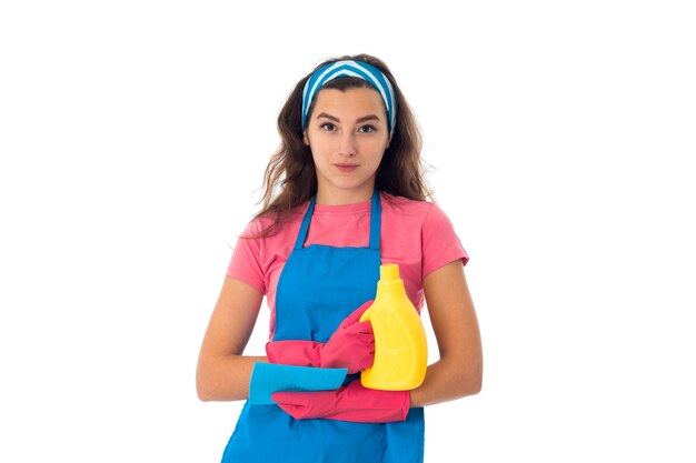 Maid woman in an apron with cleansers isolated on white wall