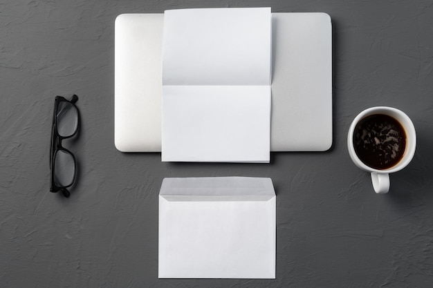 机の上の郵便封筒コーヒーペンとラップトップ