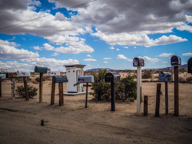 Mailboxes against cloudy sky