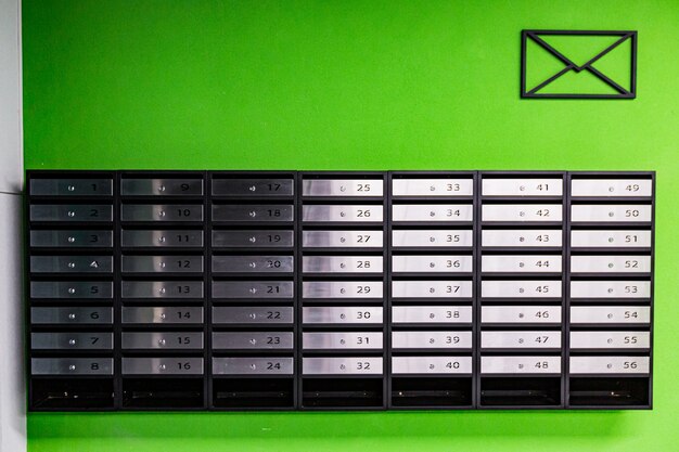 Mailboxes in an apartment building, made of stainless steel, on a green wall