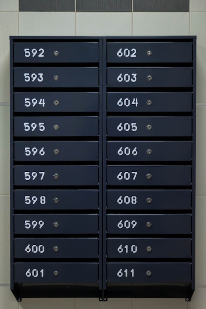 Почтовые ящики в многоквартирном жилом доме. Четные ряды пронумерованных почтовых ящиков. Концепция переписки в городе. Вы можете использовать его в качестве фона для своего объявления. Копировать пространство