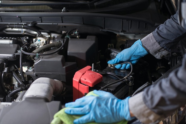 Maintenance of the engine to work efficiently technician is\
checking battery closeup