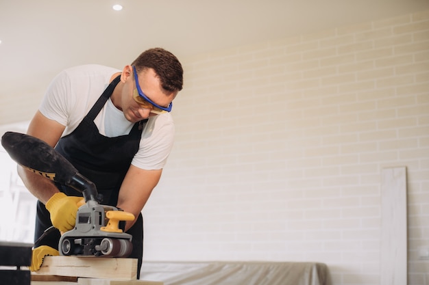 Maintenance man fixing furniture with a special equipment