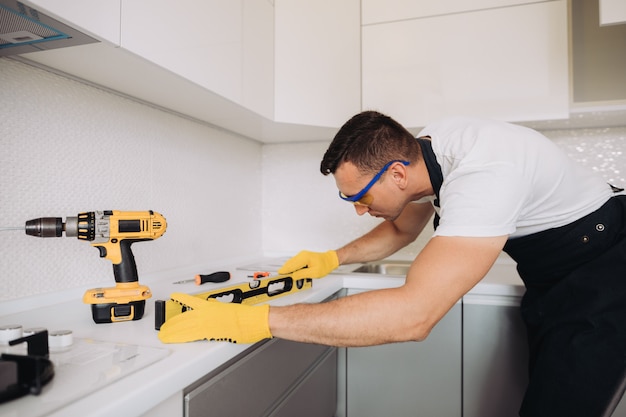 Maintenance man installing kitchen furniture