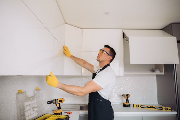 Maintenance man installing kitchen furniture