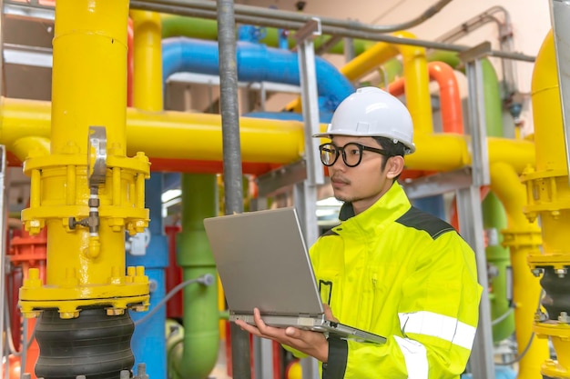 Maintenance technician at a heating plantpetrochemical workers supervise the operation of gas and oil pipelines in the factoryengineers put hearing protector at room with many pipes