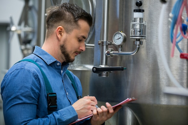 maintenance worker writing on clipboard