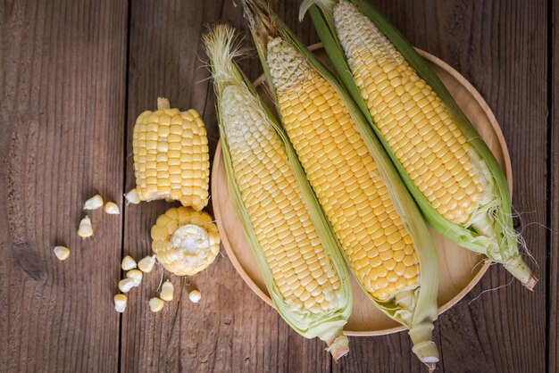 Maïskolf Suikermaïs voor het koken van voedsel Verse maïs op houten ondergrond Oogst rijpe maïs biologisch