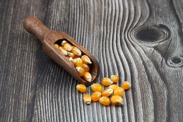 Maïszaadjes voor popcorn geïsoleerd op een donkere rustieke achtergrond