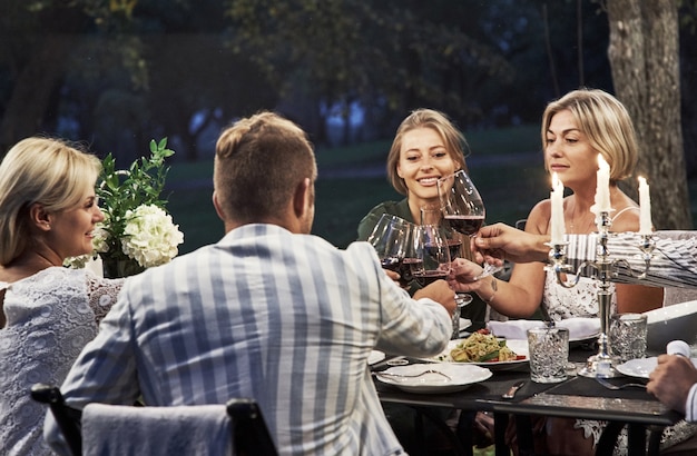 Momento maestoso. un gruppo di amici adulti ha una pausa e una conversazione nel cortile del ristorante la sera.