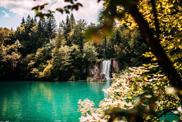 Majestic mountain waterfall and turquoise lake water.