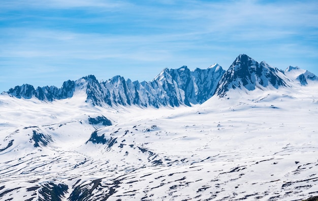 Majestic mountains of Thompson Pass rise over trees