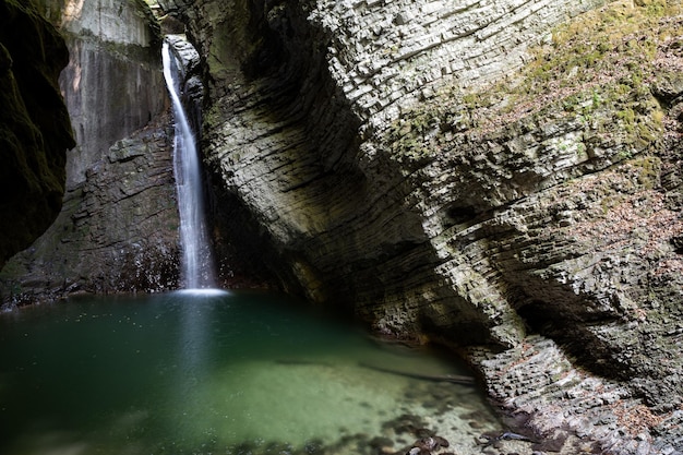 Majestic profiled high rocky cliff with waterfall kozjak