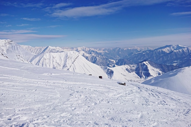 雄大な雪に覆われた山頂の風景と太陽の光の青い空