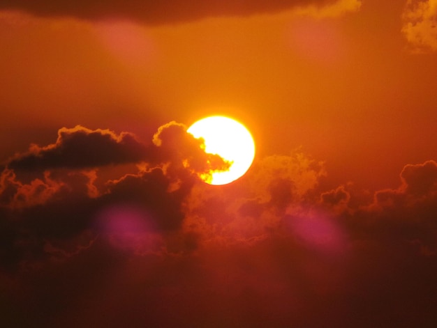 夕暮れ の 時 の 雲 の ある 空 の 中 の 太陽 の 壮大な 景色