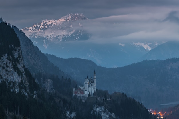 Majestueus kasteel Neuschwanstein in de schemering, omgeven door bergen