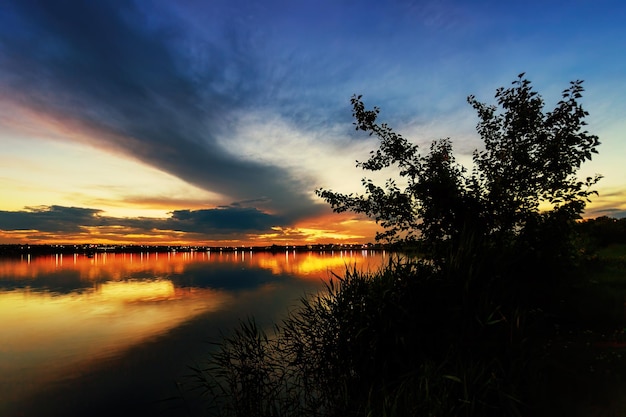 Majestueuze Lake Sunset met stedelijke gloed en opvallende wolken op de achtergrond