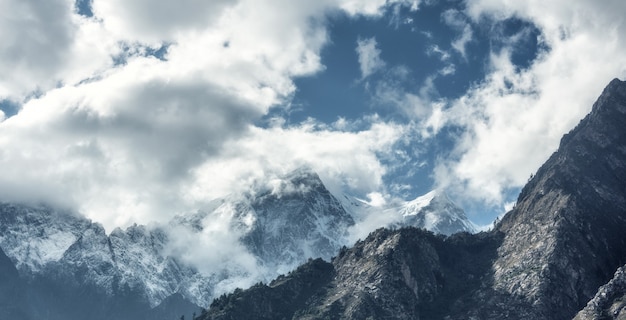 Majestueuze scène met bergen met sneeuwpieken in wolken in Nepal