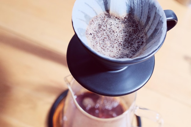 make drip coffee barista pouring water on coffee ground with filter