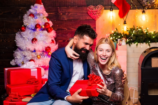 Make funny face. Fashion couple over Christmas tree lights background. Expression and people concept