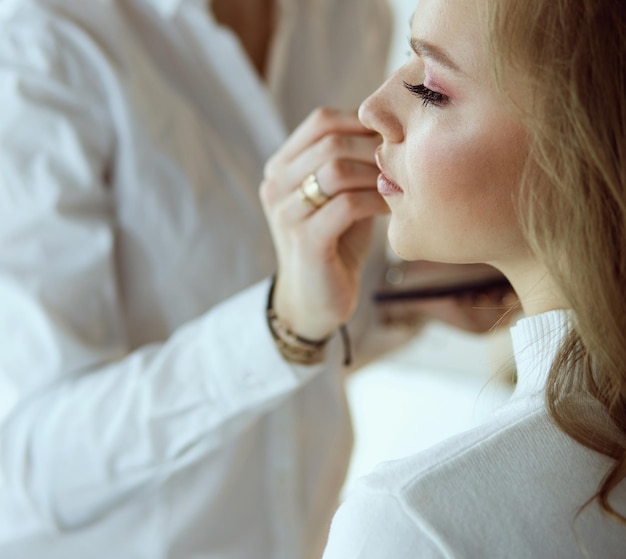 Make-up artiest doen professionele make-up van jonge vrouw