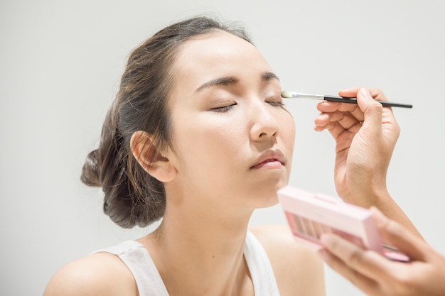 Make up artist applying make up to clean face a fashion model or bride