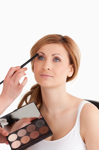 Make-up artist applying make up to a young female