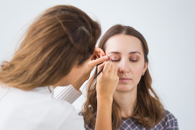 Make up artist doing professional make up of young woman