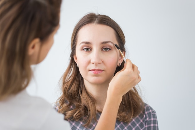 Make up artist doing professional make up of young woman