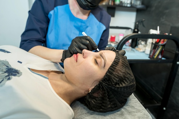 Make-up artist plukt wenkbrauwen in een schoonheidssalon Professionele make-up en cosmetologie huidverzorging