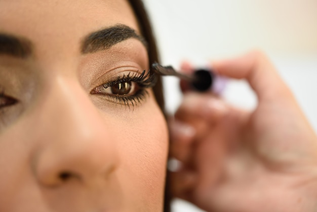 Make-up artist putting on the eyelashes of an African woman