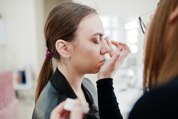 Make up artist work in her beauty visage studio salon Woman applying by professional make up master Beauty club concept