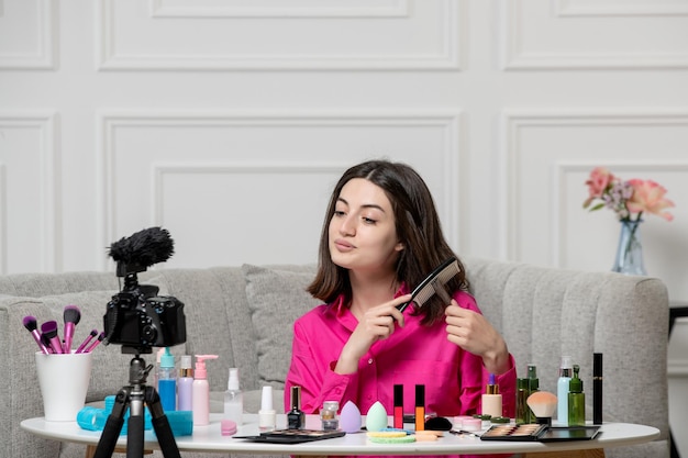 Make up blogger cute lovely beautiful young lady recording video on camera with brush