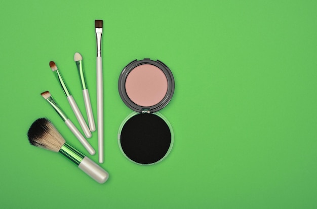 Make up blush sponge and brushes over green